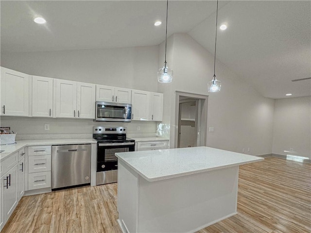 kitchen featuring high vaulted ceiling, white cabinets, pendant lighting, and appliances with stainless steel finishes