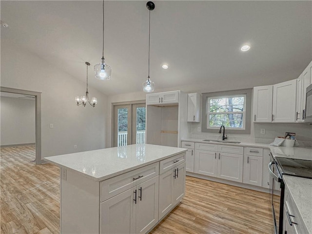 kitchen with sink, decorative light fixtures, white cabinetry, electric stove, and a center island