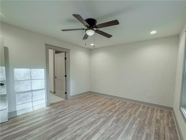 empty room with ceiling fan and light hardwood / wood-style flooring