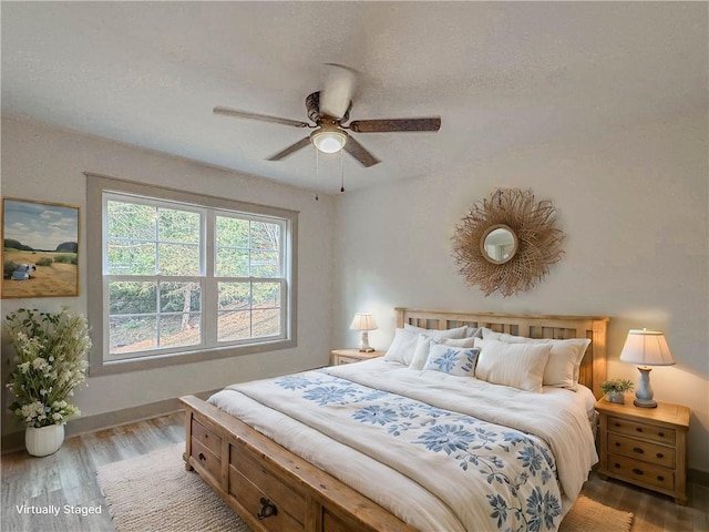 bedroom with ceiling fan, light hardwood / wood-style floors, and a textured ceiling