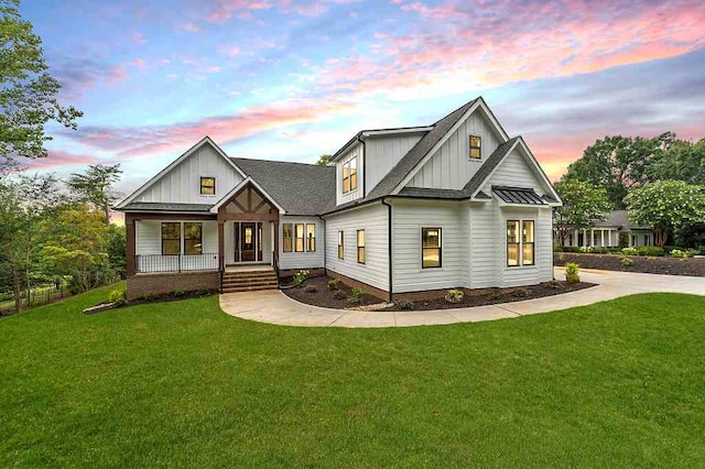 view of front of home featuring covered porch and a lawn