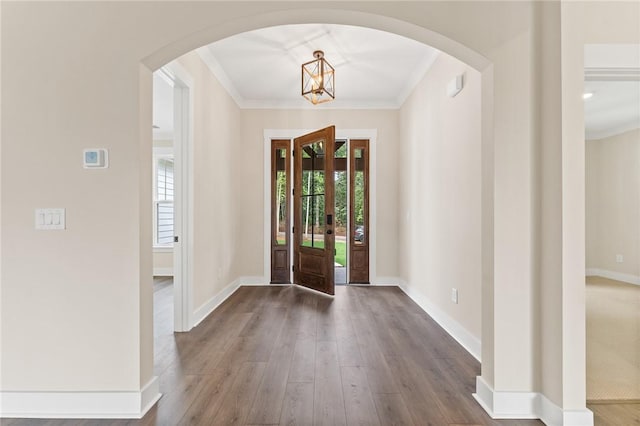 foyer with dark hardwood / wood-style floors and crown molding