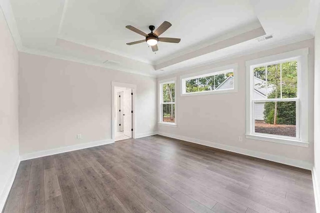 unfurnished room with ceiling fan, ornamental molding, dark hardwood / wood-style flooring, and a tray ceiling