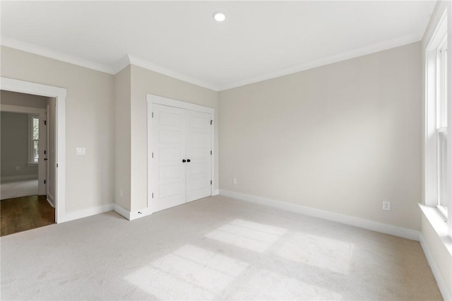 unfurnished bedroom with a closet, carpet flooring, and ornamental molding