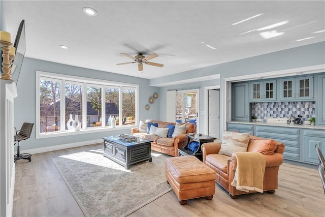 living room featuring light hardwood / wood-style floors and ceiling fan