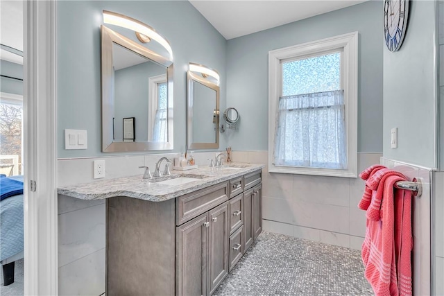 bathroom with tile walls, a wealth of natural light, and vanity