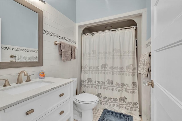 bathroom with vanity, toilet, walk in shower, and tile walls