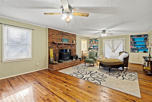 living room featuring built in shelves, hardwood / wood-style floors, and a textured ceiling