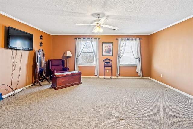 sitting room featuring ceiling fan, carpet, and ornamental molding