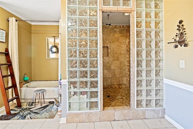 bathroom with a textured ceiling, tile patterned floors, ornamental molding, and shower with separate bathtub