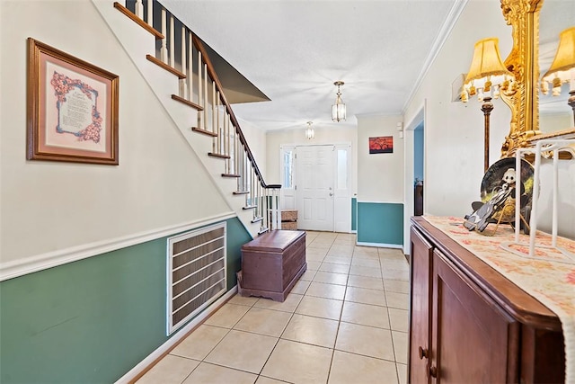 foyer featuring light tile patterned floors and ornamental molding