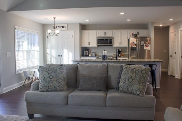 living room featuring a notable chandelier and dark hardwood / wood-style flooring