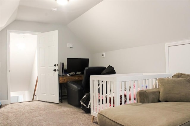 carpeted bedroom featuring vaulted ceiling and a nursery area