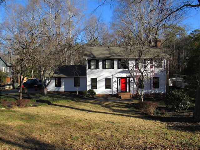 colonial-style house with a chimney and a front yard