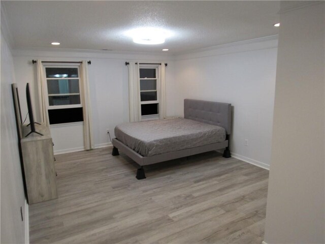 bedroom featuring a textured ceiling, light wood-style flooring, recessed lighting, baseboards, and ornamental molding