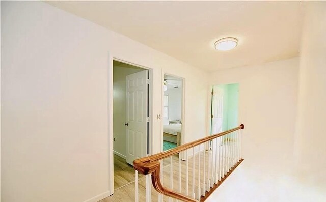 corridor with baseboards and an upstairs landing