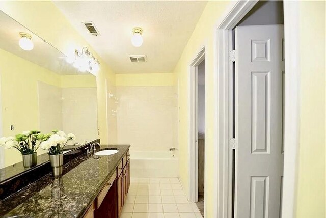 bathroom with a garden tub, vanity, visible vents, and tile patterned floors