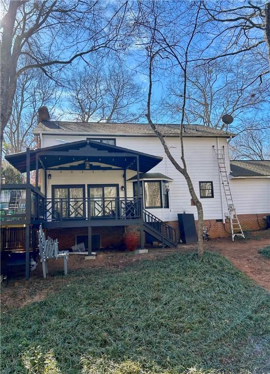 back of property with stairs, crawl space, a chimney, and a deck