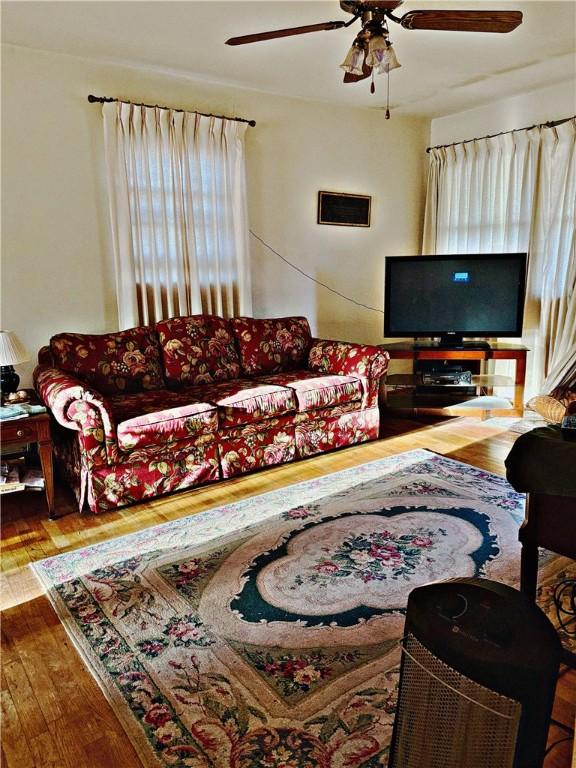 living room featuring hardwood / wood-style flooring and ceiling fan