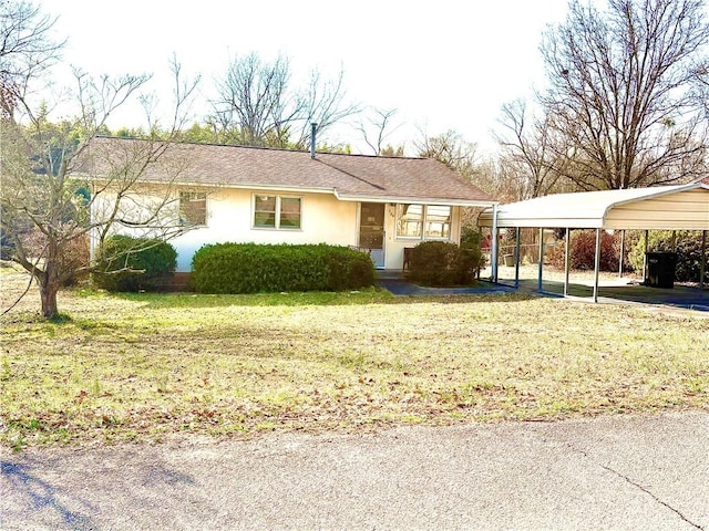 ranch-style home featuring a carport and a front yard