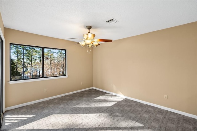 spare room with ceiling fan, carpet flooring, and a textured ceiling