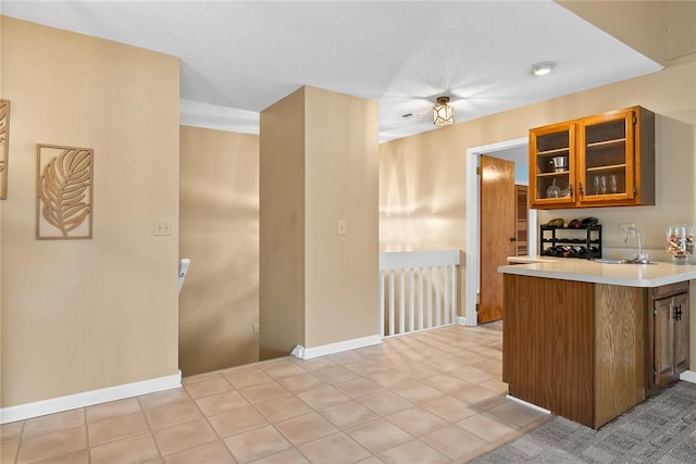 kitchen featuring sink, light tile patterned floors, and kitchen peninsula