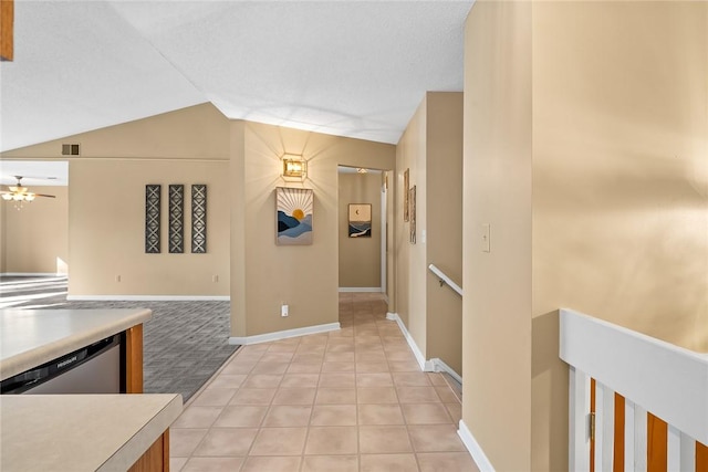 kitchen featuring light tile patterned flooring, ceiling fan, dishwasher, and vaulted ceiling