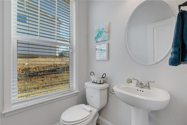 bathroom with plenty of natural light, toilet, and sink