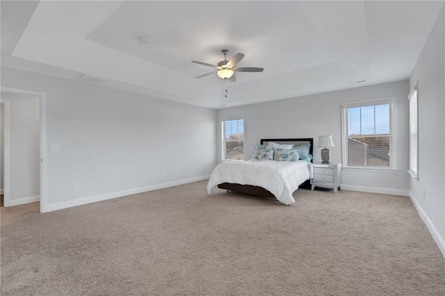 unfurnished bedroom featuring light colored carpet, a raised ceiling, and ceiling fan