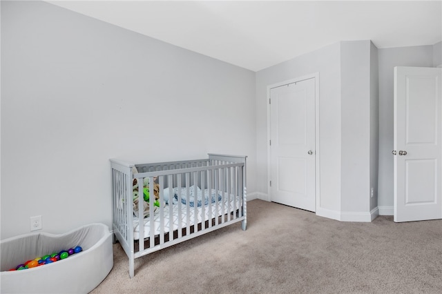 carpeted bedroom featuring a crib