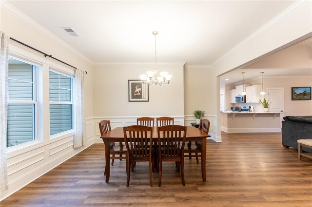 dining room featuring crown molding, dark hardwood / wood-style flooring, and a notable chandelier