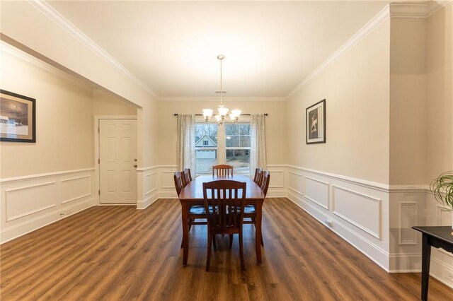 dining space with an inviting chandelier, crown molding, and dark hardwood / wood-style floors