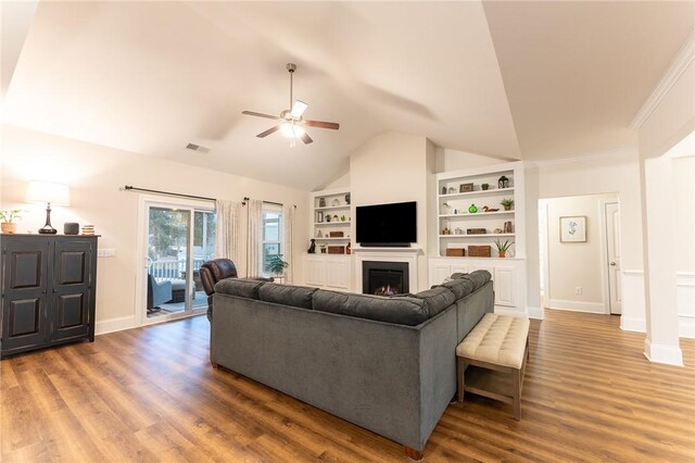 living room with hardwood / wood-style flooring, ceiling fan, vaulted ceiling, and built in shelves