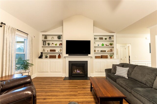 living room featuring a fireplace with flush hearth, dark wood-style flooring, vaulted ceiling, and built in shelves