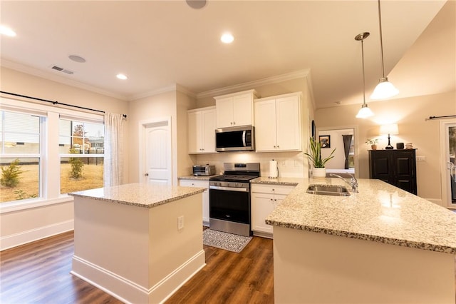 kitchen with a kitchen island, a sink, visible vents, white cabinets, and appliances with stainless steel finishes