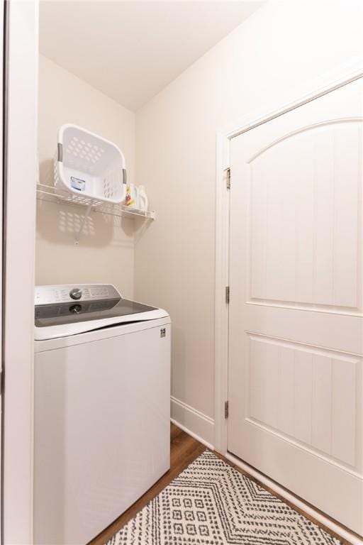 laundry room with laundry area, baseboards, washer / clothes dryer, and dark wood-style flooring