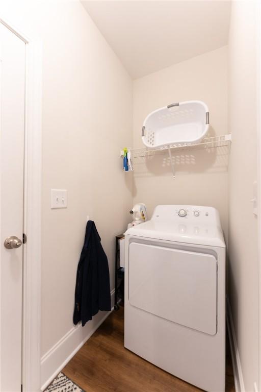 washroom with washer / dryer and dark hardwood / wood-style flooring