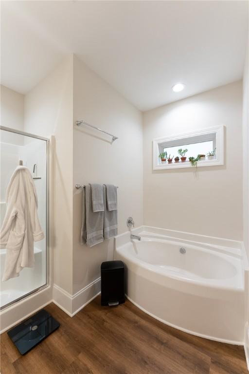 bathroom featuring hardwood / wood-style flooring and shower with separate bathtub