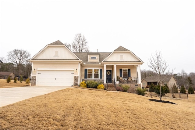 craftsman house with a garage, covered porch, and a front lawn