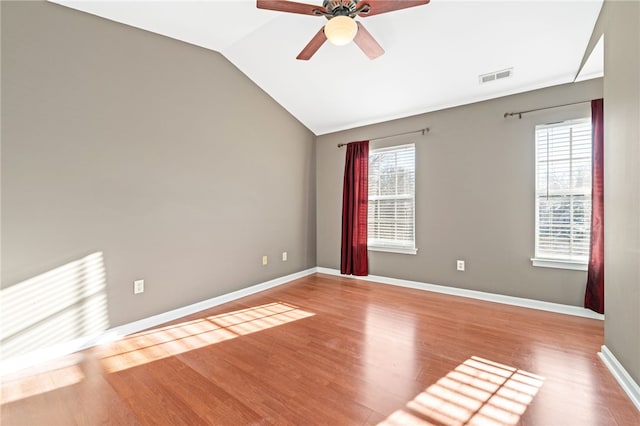 unfurnished room featuring light hardwood / wood-style flooring, a wealth of natural light, ceiling fan, and vaulted ceiling