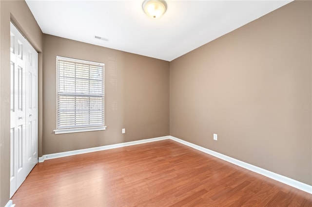 unfurnished bedroom with hardwood / wood-style flooring and a closet