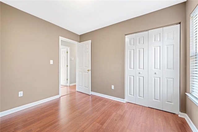 unfurnished bedroom featuring a closet and light wood-type flooring