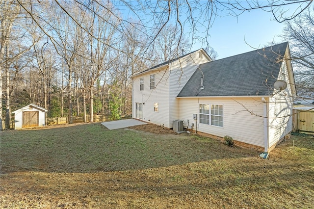 rear view of property with a storage unit, a yard, and central air condition unit