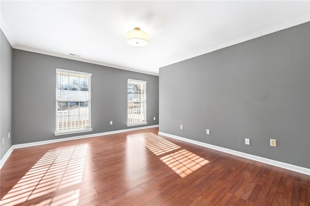 empty room featuring crown molding and wood-type flooring