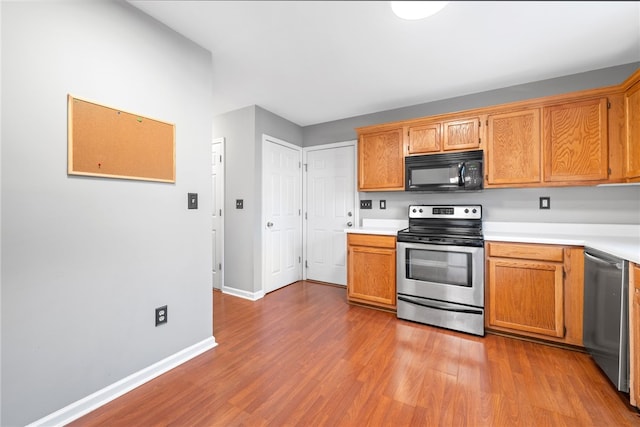 kitchen with appliances with stainless steel finishes and light hardwood / wood-style floors