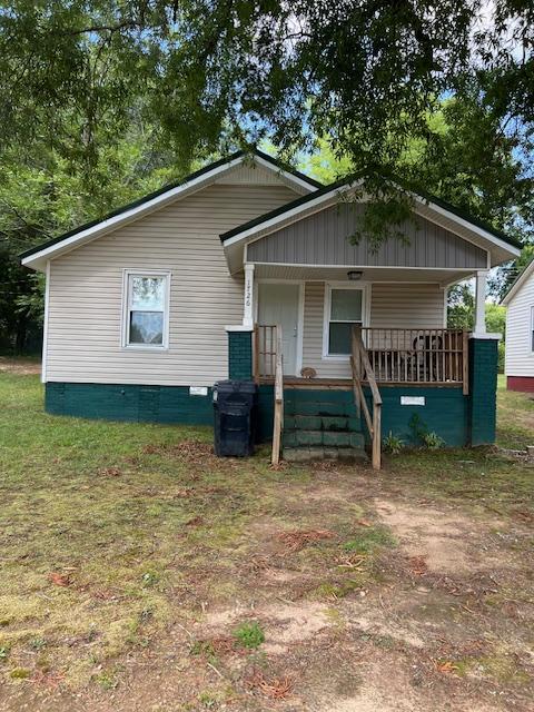 exterior space featuring covered porch and a front lawn