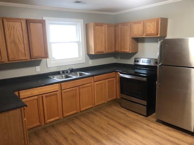 kitchen with sink, crown molding, light hardwood / wood-style flooring, and stainless steel appliances