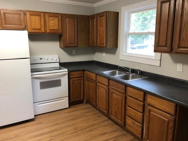 kitchen featuring crown molding, sink, white appliances, and light wood-type flooring