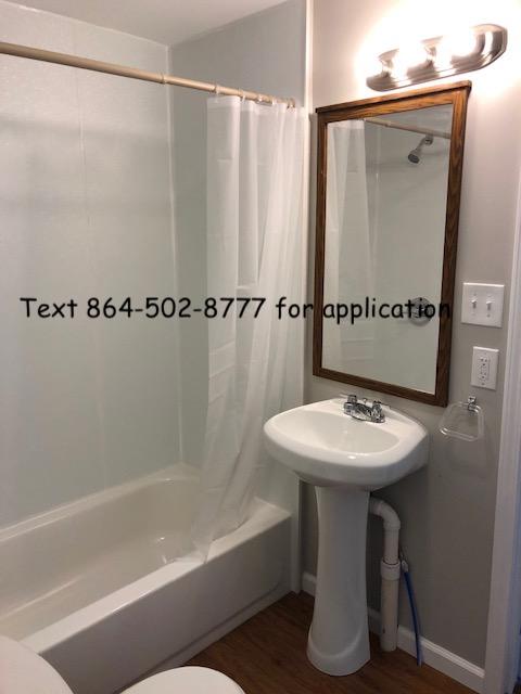 full bathroom with hardwood / wood-style flooring, shower / tub combo with curtain, toilet, and sink