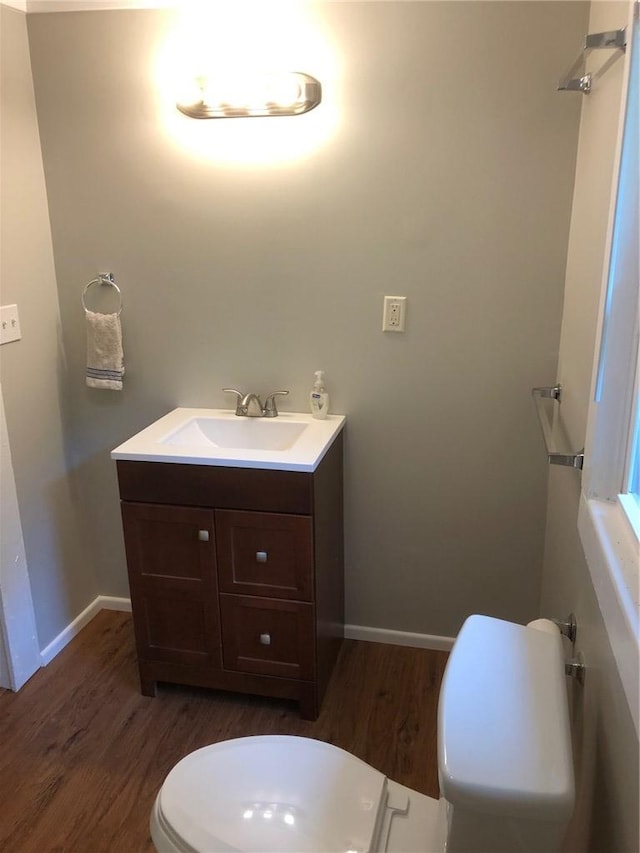 bathroom with hardwood / wood-style flooring, vanity, and toilet